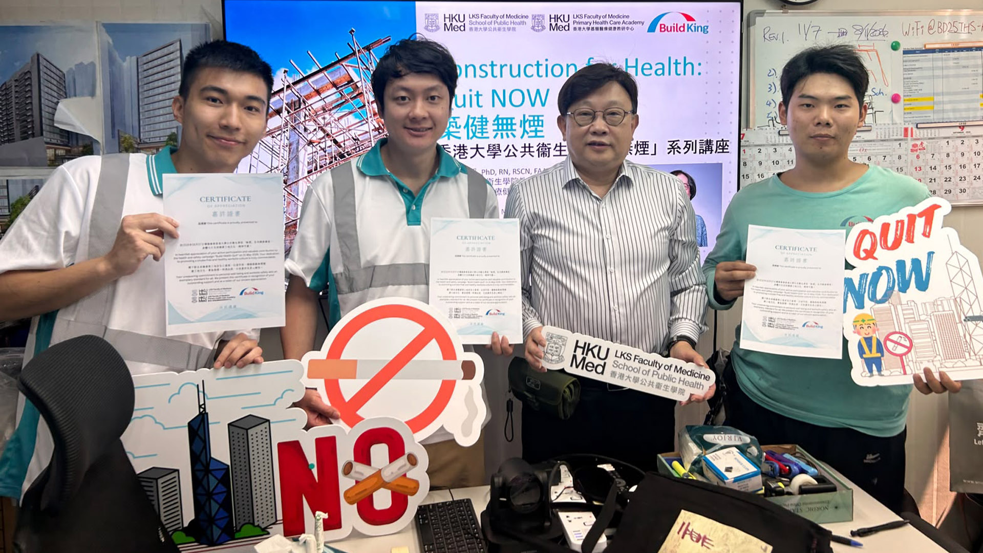 Quit Now Project outreach activity — staff and workers holding certificates